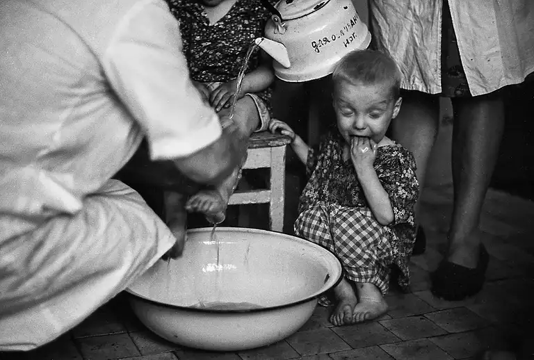 Inadvertently, one of the children, attracted by the sound of pouring water, quenches his thirst by dipping his hand into the basin. Specialized Children's Home No. 2, which houses children with congenital malformations, postpartum injuries, and those who, according to doctors, cannot live among ordinary children. St. Michurina. Novokuznetsk. Kemerovo region. Kuzbass. Siberia. 06/08/1981 Photo Vladimir Sokolaev/Liberty SU Archive