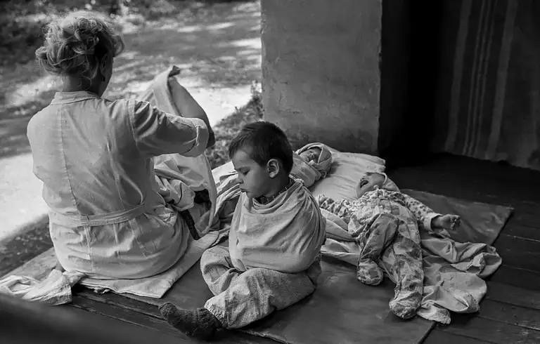 The teacher wrapped a diaper around the child's hands to protect herself and other children from his pinches and blows. Specialized Children's Home No. 2, which houses children with congenital malformations, postpartum injuries, and those who, according to doctors, cannot live among ordinary children. St. Michurina. Novokuznetsk. Kemerovo region. Kuzbass. Siberia. 06/08/1981 Photo Vladimir Sokolaev/Liberty SU Archive