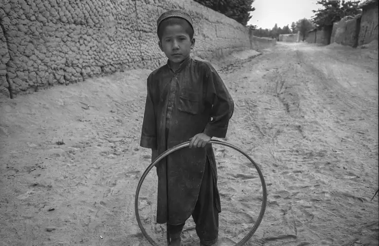 A boy with a broken bicycle wheel. Northern Afghanistan, October, 2001. Photo by Oleg Klimov
