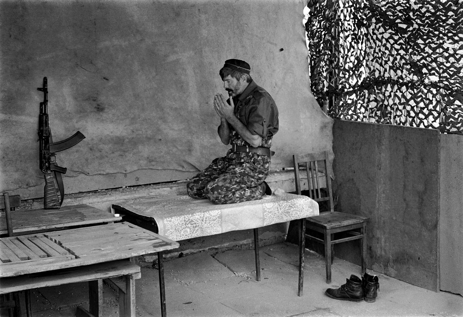 Chechen rebel prays before battle, 2001. Grozny, Chechnya, Russia. Photo by Oleg Klimov.